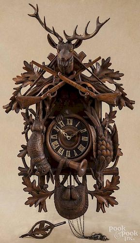 German Black Forest carved cuckoo clock, late 19th c., having a stag and gun crest