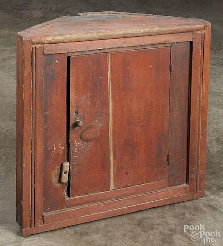 Pennsylvania painted pine hanging corner cupboard, 19th c., retaining an old red surface, 23 1/2'' h.
