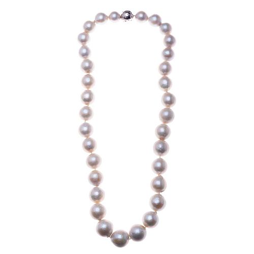Collar con 33 perlas cultivadas color blanco de 14 a 17 mm. Broche con chispas de diamantes en paladio.  197.6 g. Muestra desg...