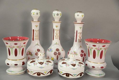 Group of eight white cut to cranberry glass pieces to include three large decanters, two large vases, and pair of covered dishes. ht...