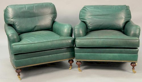 Pair of green leather easy chairs (some soiling).