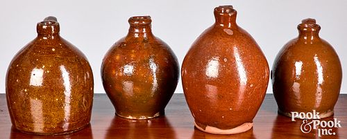 Four graduated redware jugs, 19th c.