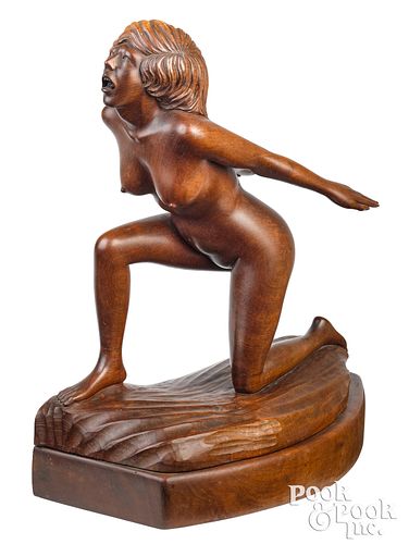 Carved figure of a nude woman riding a wave