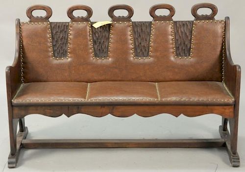 Carved bench with leather upholstery. ht. 32 in.; wd. 50 in.
