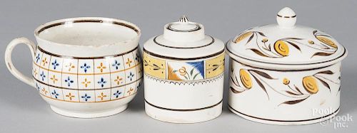 Three pieces of English pearlware, 19th c., to include a tea caddy, a covered canister, and a mug.