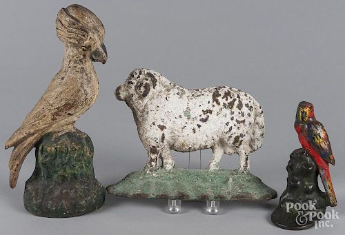 Two painted cast iron bird doorstops, 6 1/2'' h. and 11 3/4'' h., together with a sheep doorstop