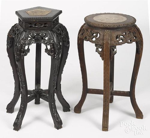 Two Chinese carved hardwood stands, early 20th c., with marble inset tops, 24'' h. and 26'' h.
