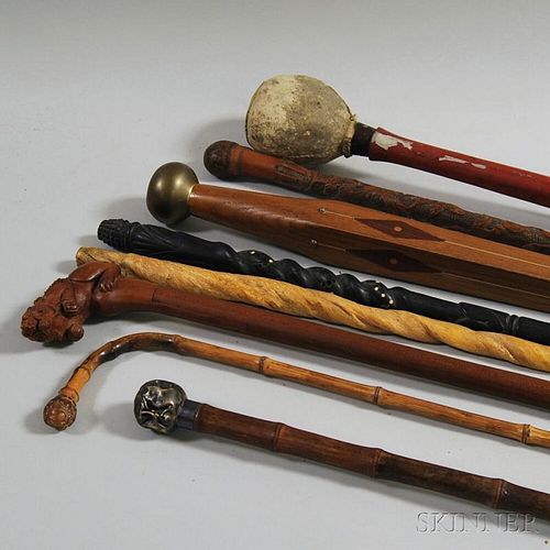 Seven Mostly Carved Walking Sticks and a Club