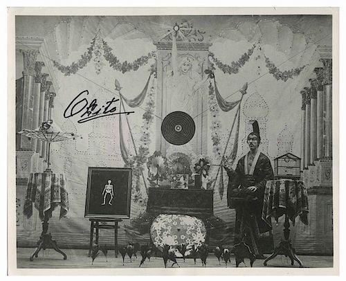 Okito (Tobias Bamberg). Signed photograph of Okito. A later print, ca. 1960. Horizontal image of a young Okito standing on stage amidst the props used