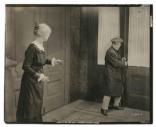 Houdini, Harry. Portrait of Houdini in The Grim Game. Los Angeles: Paramount, 1919. Houdini, clad in a coat and cap, scowls at a lady as he moves towa