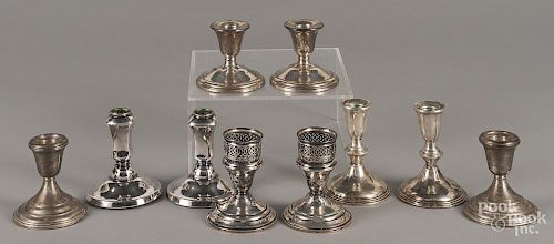 Five pairs of weighted sterling silver candlesticks.