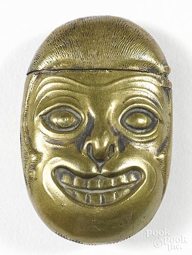 Embossed brass figural match vesta safe with opposing faces, 1 3/4'' h.