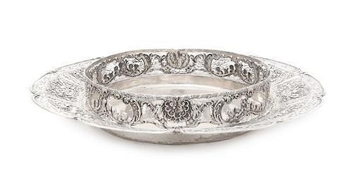 * A German Silver Dish, Circa 1927, shaped circular, the border pierced and chased with panels of rosebuds, baskets of flowers a