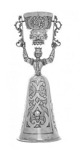 A German Silver Wager Cup, B. Neresheimer & Sohne, Hanau, Circa 1900, in the form of a maiden holding a swivelling cup chased wi