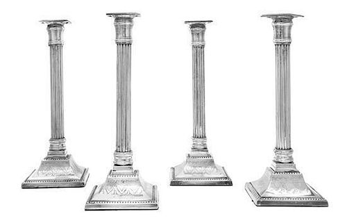* A Set of Four George III Sheffield-Plate Candlesticks, Circa 1800, on stepped square bases, engraved with foliate swags, risin