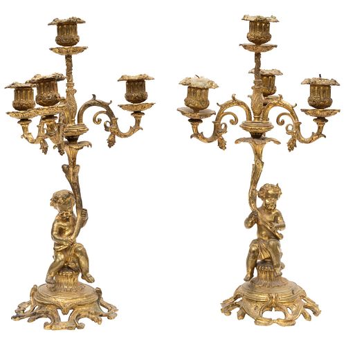 PAR DE CANDELABROS FRANCIA, CA. 1900 Fundición en bronce. Para 4 luces Fuste a manera de amorcillos sosteniendo acantos. 44 cm de alto.