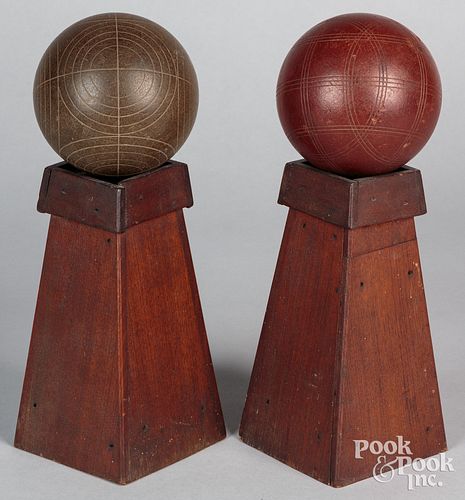 Two carpet balls, 19th c., resting on pine plinths
