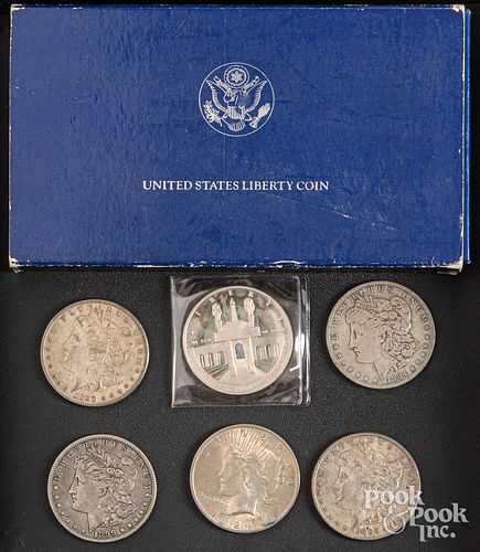 Seven silver dollars, to include four Morgan