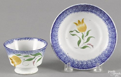 Miniature blue spatter cup and saucer with yellow tulip decoration.
