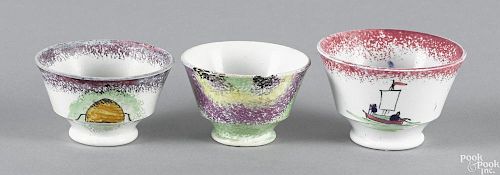 Three miniature spatter cups, to include a red raft, a green, purple, yellow, and black drape