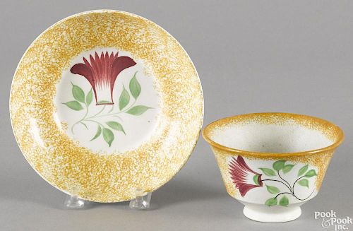 Yellow spatter cup and saucer with thistle decoration.