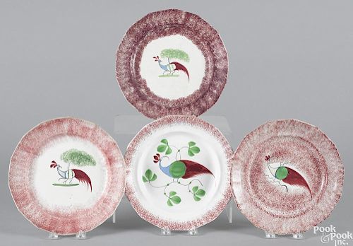 Four red spatter plates with peafowl decoration, approximately 9 3/8'' dia.
