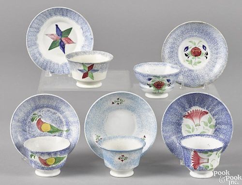 Five blue spatter cups and saucers with peafowl, pomegranate, thistle, star, and sprig decoration.
