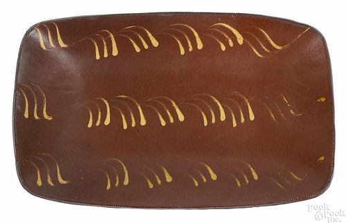 New England redware loaf dish, 19th c., with yellow slip decoration, 10'' h., 16'' w.