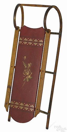 Painted sled, late 19th c., retaining its original red surface with floral highlights, 40'' l.