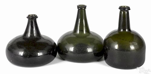 Two blown olive glass squat bottles, 18th c., 5 3/4'' h. and 6 3/4'' h.