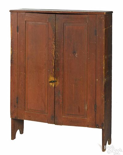 Painted pine wall cupboard, ca. 1810, retaining an old red surface, 56'' h., 40 1/2'' w.