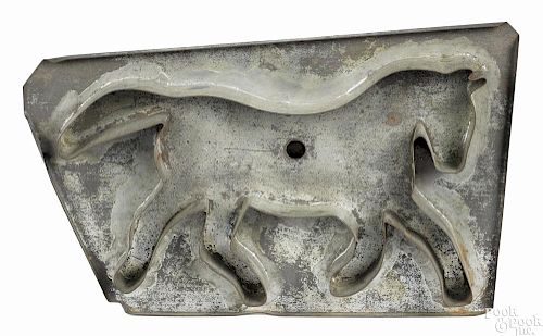 Large tin horse-form cookie cutter, late 19th c., the handle stamped Thos. Miller & Bro.