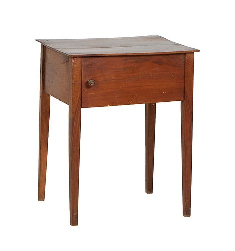French Provincial Carved Walnut Side Table, early 20th c., the rectangular top over a deep skirt, above a large cupboard door, on tapered square legs,
