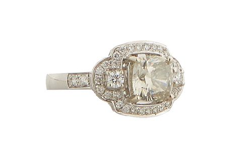 Lady's 14K Dinner Ring, with a very light yellow round 2.43 carat diamond atop a curved top mounted with numerous small round diamonds, the shoulders 