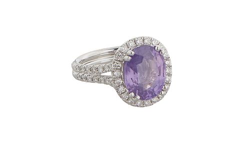 Lady's 18K White Gold Dinner Ring, with an oval 4.6 carat purple sapphire atop a double concentric octagonal border of small round diamonds, the split