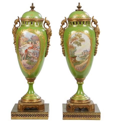 Pair of Sevres Style Hand Painted Porcelain and Gilt Bronze Covered Urn Garnitures, early 20th c., with gilt decoration on a green ground, and mask ha