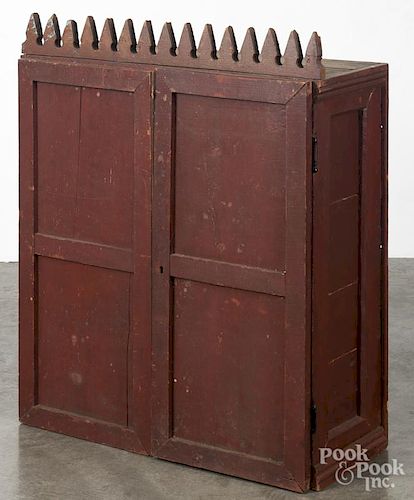 Primitive painted pine hanging cubby hole cabinet, 19th c., with a sawtooth crest