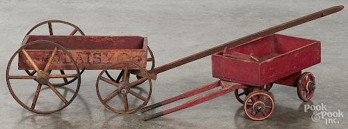 Two painted wood child's pull wagons, retaining a red surface, one stenciled Daisy, 15'' l.