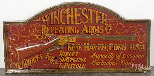 Reproduction Winchester Repeating Arms Co. painted wood sign with a relief carved rifle