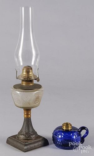 Cast iron and frosted glass kerosene lamp, 19th c., with repeating panels of shields