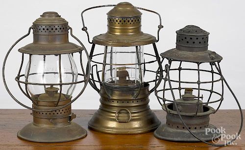 Three brass railroad lanterns, ca. 1900, one Dietz with a paneled globe
