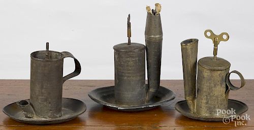 Three tin lard lamps, 19th c., with a key wound push rod, 7 1/4'' h.