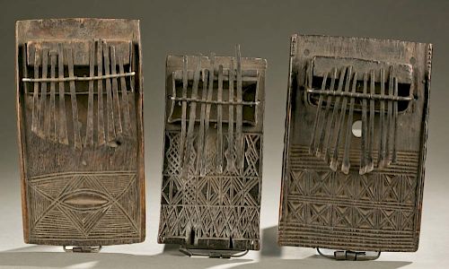 2 thumb pianos with carved linear motifs.