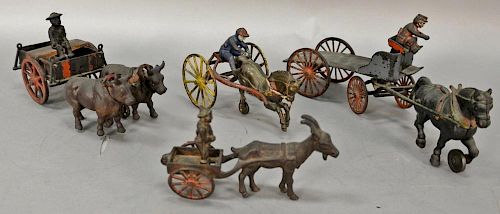 Group of four cast iron toys including dray horse drawn wagon with driver (missing stakes), small goat drawn cart with rider, horse ...
