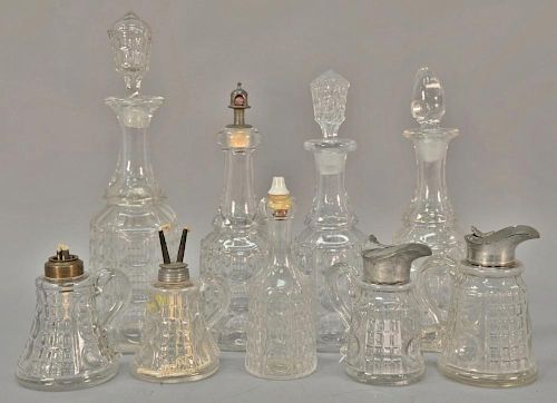 Nine piece lot of Waffle pattern flint glass including four decanters, one cruet, two syrups, two small oil lamps. ht. 5in. to 8in.