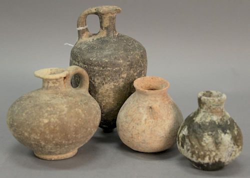 Four ancient stone and clay urns including a terracotta handled vase, two stone handled jugs, and a small molded vase. ht. 3 3/4in. ...