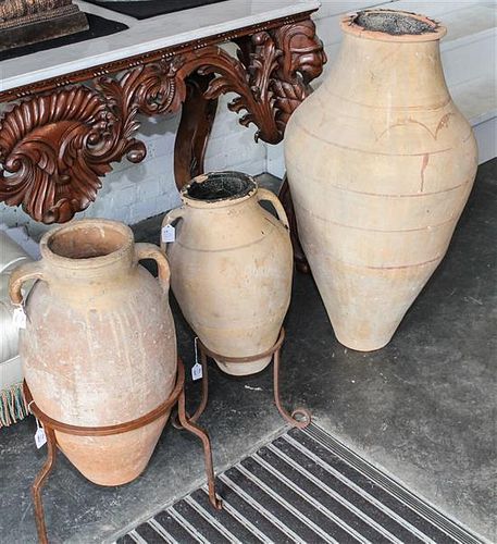 * A Suite of Three Persian Terracotta Olive Oil Storage Jars Height of tallest 42 inches.