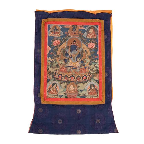 THANGKA. SXX. Temple sobre tela sobre bordado en textil. Cenefa en color azul, ocre y rojo. Decorado con figura central  de Buda azul.