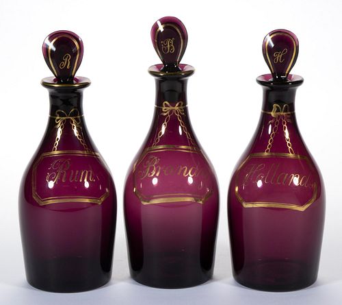 ENGLISH FREE-BLOWN COLORED GLASS THREE-BOTTLE DECANTER SET