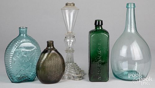 Four early glass bottles and a fluid lamp